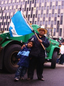 A man and his son wave the flag of El Salvador at an immigration rally in New York City.