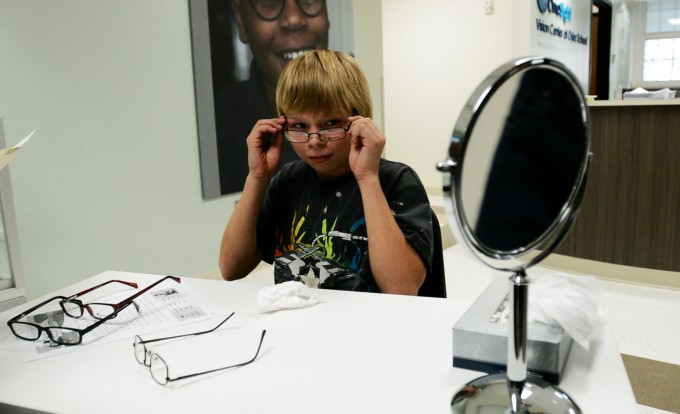 Timothy Drifmeyer, age 13, tries on glasses at the OneSight Vision Center inside Oyler School. Opened in 2012, the center provides free eye exams and glasses to children throughout the school district. Established through philanthropy, the clinic sustains itself by billing Medicaid or, if a family has it, private insurance. Before the clinic opened, around 140 kids at Oyler failed a routine eye screening each year, but many went untreated. “Poverty interferes with children getting health care,” says Marilyn Crumpton with the Cincinnati Health Department. Photo by Stacy Doose. © 2013, Amy Scott.