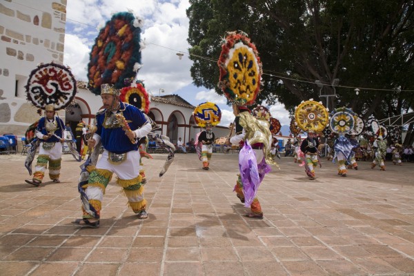 The name of the city, Teotitlán, comes from Nahuatl and means “land of the gods”. Its Zapotec name is Xaguixe, which means “at the foot of the mountain”. It still retains its Zapotec culture and language. The dance is performed in the town plaza in front of the Preciosa Sangre de Cristo Church, begun in 1581 and completed in 1758. The church sits on the ruins of a Zapotec temple, which the Spanish destroyed.