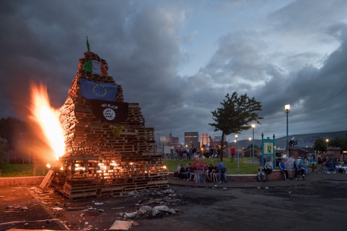 Belfast’s extended twilight makes for some spectacular scenes. This children’s bonfire is dressed with two Irish tricolors, the European Union flag, the Isis flag, and a jersey from the Celtic Football Club.